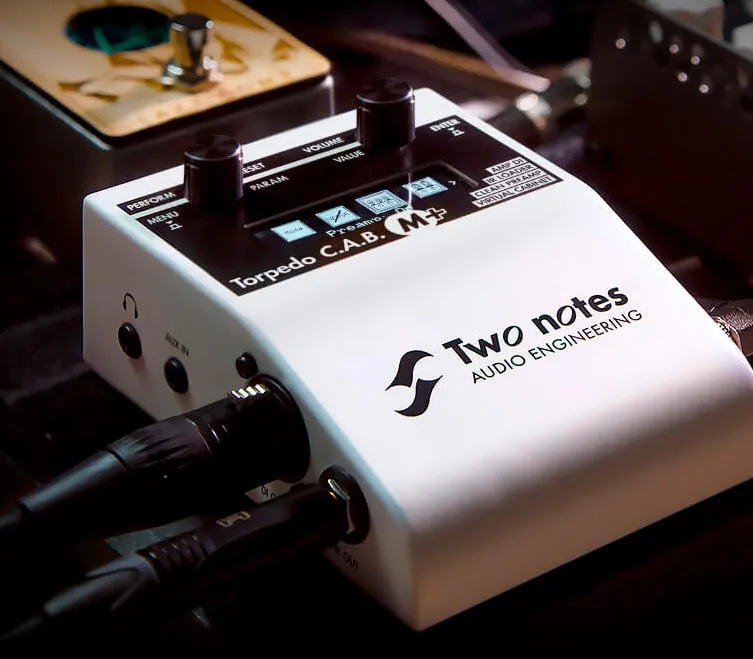 The white Two Notes CABM+ guitar pedal set-up ready to use next to other equipment